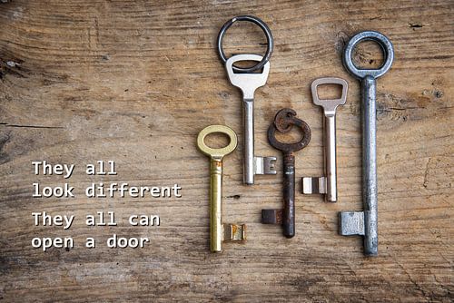 Verschillende sleutels op een rustieke houten plank, concept voor integratie van immigranten en vluc