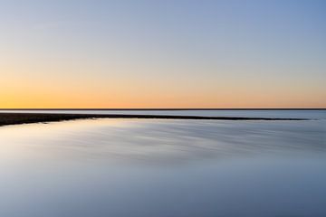 Oranje zonsondergang in een oase van blauw van Claire van Dun