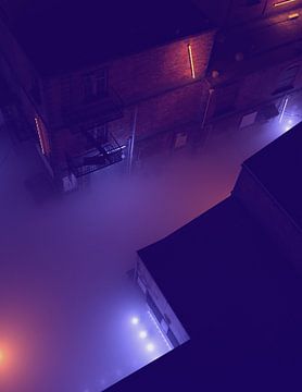 Luchtfoto van een mistig steegje in de nacht verlicht door neonlichten. van Ysbrand Cosijn