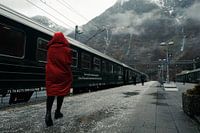 Vrouw in rode jas op Flam station, Noorwegen