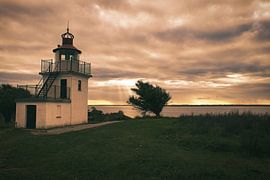 Lighthouse by the sea and rays of sunshine by Martin Köbsch