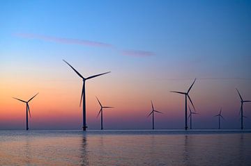 Windturbines in een offshore windpark tijdens zonsondergang