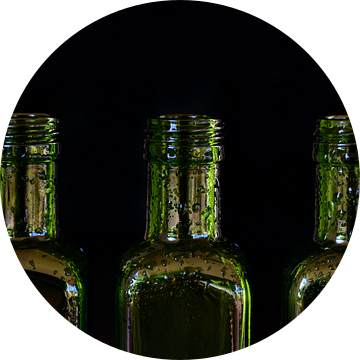 drie lege groene glazen flessen met druppels water van Ulrike Leone