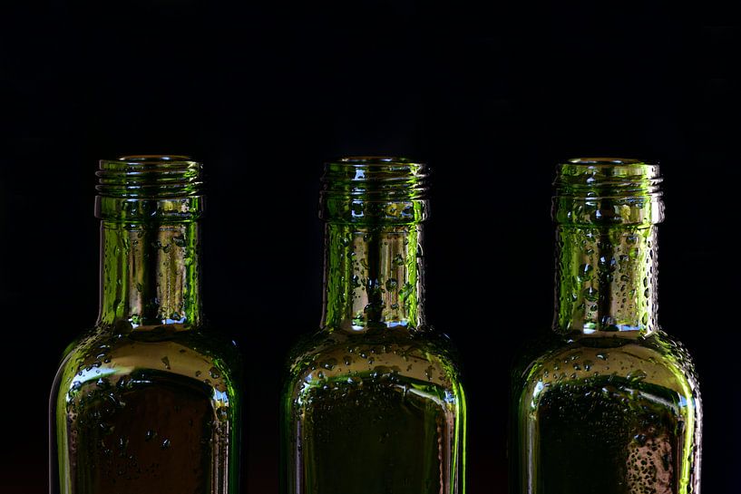 drei leere grüne Flaschen aus Glas mit Wassertropfen von Ulrike Leone