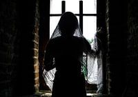 Mysterious lady looks out the window of the castle
