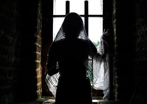 Dame mystérieuse regarde par la fenêtre du château