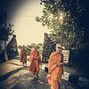 Drie boeddhistische monniken in Tanah Lot van Loris Photography