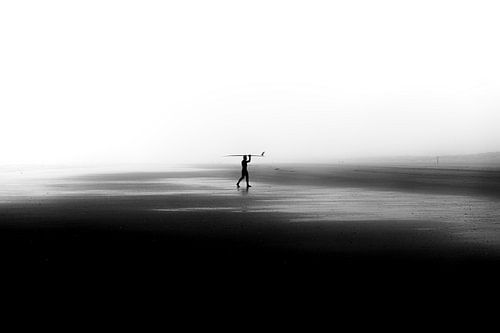 Surfer on empty beach by Tomas Grootveld