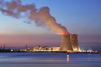 River and embankment with nuclear reactor Doel at sunset