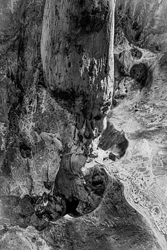 Un gnome s'accroupit sous une stalactite dans une grotte de pierre poreuse. sur kall3bu
