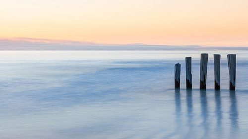 Brise-lames au coucher du soleil sur Ameland, Pays-Bas