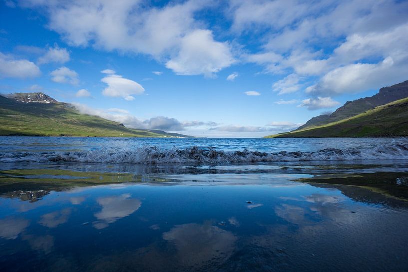 Iceland - Reflecting sky and clouds at lonely black sand beach by adventure-photos