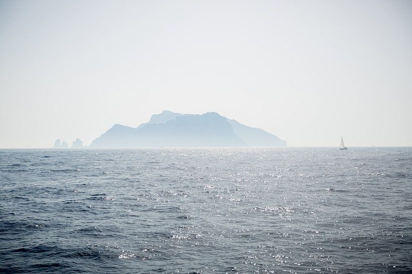 A sailboat sails off an island on the Amalfi coast in Italy by Esther esbes - kleurrijke reisfotografie