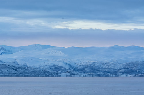 Majestueuses montagnes enneigées au bord d'un lac gelé