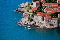 Old houses covered with red tiles and bright blue sea close-up Montenegro, Sveti Stefan. by Michael Semenov thumbnail