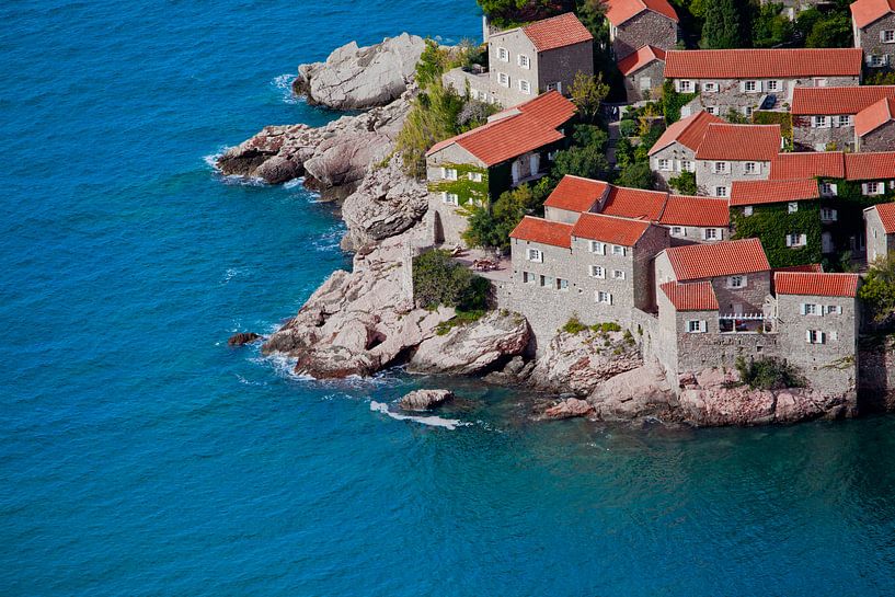 Old houses covered with red tiles and bright blue sea close-up Montenegro, Sveti Stefan. by Michael Semenov