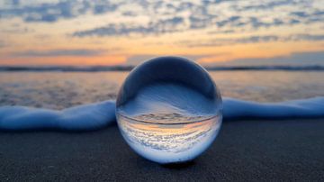 Sonnenuntergangsreflexion in Glaskugel von Monique van Middelkoop