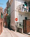 Gekleurde huisjes in de smalle straatjes op het Italiaanse eiland Procida van Michiel Dros thumbnail