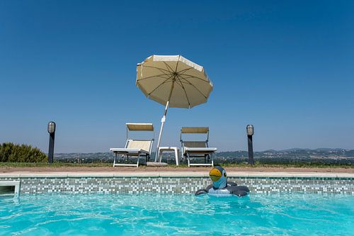 Een zonsondergang met zwembad en blauw water in, Toscane, Italië.