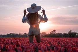 Vrouw met zonnehoed in het tulpenveld van Yorick Leusink