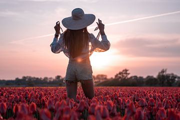 Femme avec un chapeau de soleil dans un champ de tulipes
