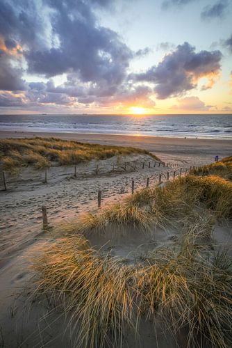 Zonsondergang aan duinen en strand
