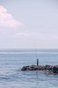 Visser langs de zee in Lombok van Mickéle Godderis