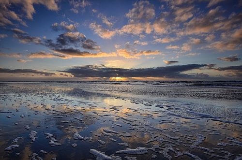 Soleil couchant se reflétant dans la plage humide de la mer du Nord près de Bergen aan Zee sur Martin Jansen
