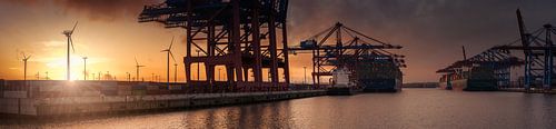 Container terminal at sunset with wind turbines