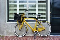 Gele retro-fiets geparkeerd tegen een huis van Tony Vingerhoets thumbnail