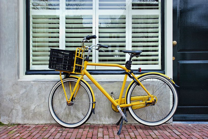 Gele retro-fiets geparkeerd tegen een huis van Tony Vingerhoets