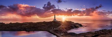 Insel Menorca mit Leuchtturm und Sonnenaufgang am Meer.