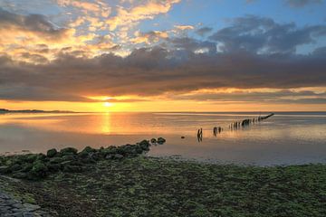 zonsondergang boven wadden zee met palen rij van FotoBob
