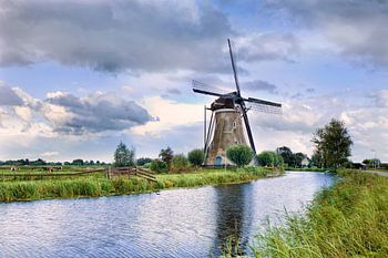 Nederlandse landschap met oude bakstenen molen in de buurt van een kleine gracht
