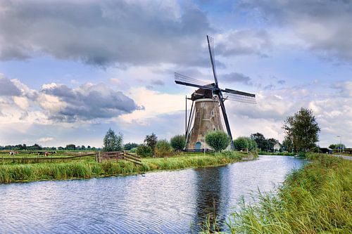 Dutch scenery with ancient brick windmill near a small canal
