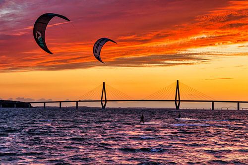 Twee kitesurfers bij een van de Farø bruggen bij zonsondergang