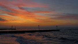 Lichtende hemel na zonsondergang op het strand van Kolobrzeg in Polen van Heiko Kueverling