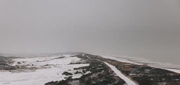 Besneeuw duinpad langs de kustlijn