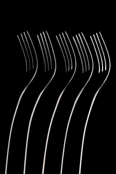 Abstract artistic photograph of cutlery, being five standing forks in a dark field arrangement by Tonko Oosterink