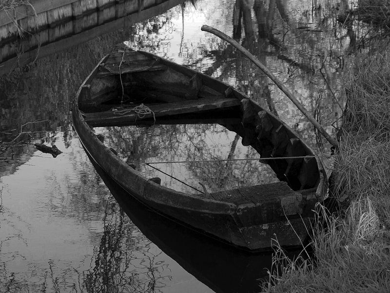 Zwart wit foto van een verlaten roeiboot van Dick de Vries