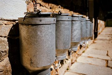 Bidons à lait sur le mur sur Holger Spieker