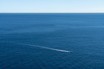 Un bateau glisse sur la mer bleue et calme