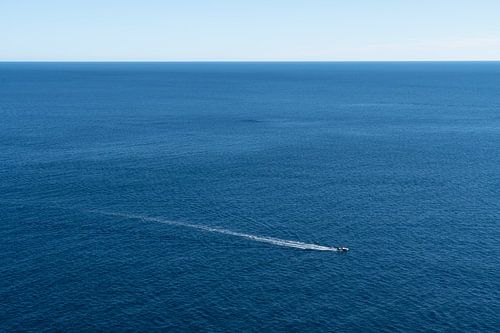 Een boot glijdt over de kalme blauwe zee