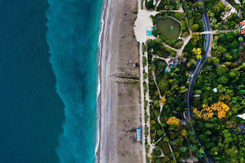 Park with a pond and the road. Hotels among the green park on the seafront with turquoise water and  by Michael Semenov