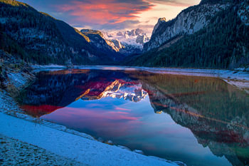 Scenic sunset panorama of blue alps lake Gosau under Dachstein mountain