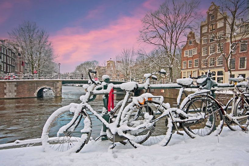 Snow-covered Amsterdam in the Netherlands in winter at sunset by Eye on You