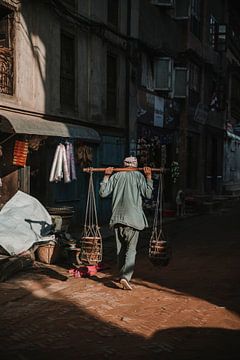 Nepalese man draagt spullen in de avondzon van Ayla Maagdenberg