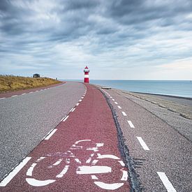 Bike path on seawall at Dutch coast lighthouse by Fotografiecor .nl