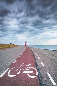 Fahrradweg auf dem Seedeich am Leuchtturm an der niederländischen Küste