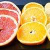 Citrus fruit sliced and arranged on a black serving platter by Babetts Bildergalerie